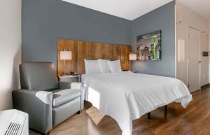 默里迪恩Extended Stay America Premier Suites - Boise - Meridian的一间卧室配有一张大床和一把椅子