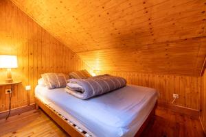PuyvaladorChalet Sérénité - Tranquillité et Très Belle Vue的木制客房内的一间卧室,配有一张床