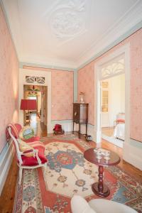 波尔图Palace Museum - Espaço Palmeiras的客厅配有粉红色的壁纸和桌椅