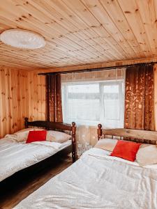 珀尔瓦Käopesa Kodumajutus的配有木墙和窗户的客房内的两张床