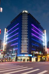 台北洛碁大饭店驿馆的一座蓝色的大建筑,上面有紫色的灯