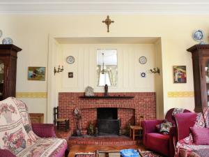 RuiseledeComfortable Mansion in Doomkerke near Forest的客厅设有砖砌壁炉和紫色椅子