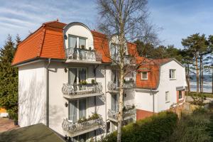 宾茨Appartement-Villa Steinfurth的白色建筑,有橙色屋顶