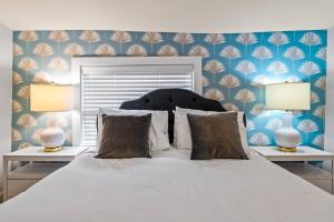 圣奥古斯丁Casa Lovett - Tropical Bungalow的卧室配有带两盏灯的白色床