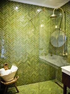 舍夫沙万Dar Jasmine的浴室设有玻璃淋浴和椅子