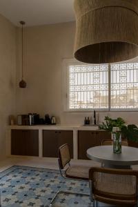 坎佩切Narrativ Lofts - Numen - Stylish Hideaway的厨房配有桌椅和窗户。