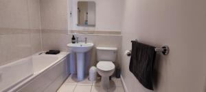 伦敦ExCel Exhibition Center Apartment的浴室配有盥洗盆、卫生间和浴缸。