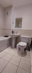 伦敦ExCel Exhibition Center Apartment的浴室配有卫生间、盥洗盆和浴缸。
