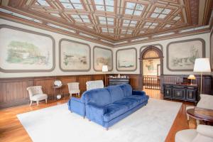 波尔图Palace Museum - Espaço Palmeiras的客厅设有蓝色的沙发和窗户。