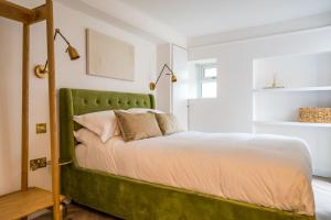 斯托昂泽沃尔德Luxe Contemporary Cotswold Pad - Heart of Stow的卧室内一张带绿色床头板的床
