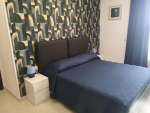 贾迪尼-纳克索斯Tulla's的一间卧室配有一张蓝色的床和一张图案墙壁