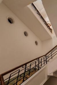 坎佩切Narrativ Lofts - Lira - Mid Century Cozy Retreat的白色墙壁和黑色栏杆的楼梯