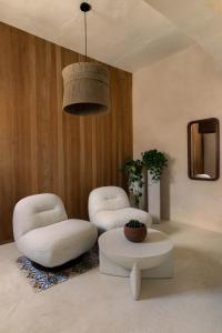 坎佩切Narrativ Lofts - Lira - Mid Century Cozy Retreat的客厅配有两把椅子和一张桌子