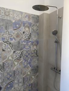 伊奥斯乔拉Luxury studio on the beach的浴室设有蓝色和白色瓷砖淋浴。