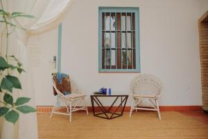 科尔多瓦Palacete del Águila的窗户客房内的两把椅子和一张桌子