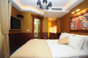 蒂瓦特Luxury Sea Residence by Kristina的一间卧室配有一张带吊灯的床和一台电视。