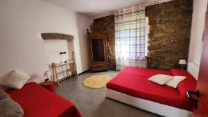 贝加莫Comfort Accommodation Residence的一间卧室设有红色的床和石墙