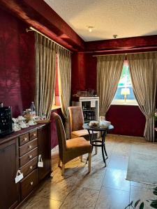 锡默拉特Garni Hotel Henn的客厅设有红色的墙壁和桌椅