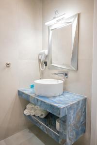 弗洛伊塔Fay Suites的一间带水槽和镜子的浴室