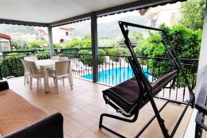 马尔马里斯Arslan Villa with Pool的一个带桌椅的阳台和一个游泳池