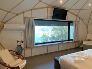 巴约讷GLAMPING DO MAR的帐篷内带大窗户的房间