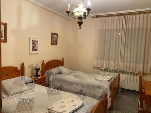 布龙查莱斯Casa Rural María Josefa的一间卧室设有两张单人床和一个窗户。