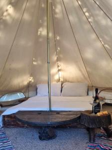 旧瓦马Megic Garden Bell Tent的帐篷内的一张床位,配有木桌
