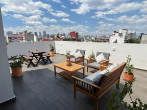 墨西哥城Baja California 279 Apartments的屋顶上带桌椅的天井