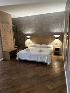 蒙特-坡佐-卡多Casa Catone (affitta camere)的卧室配有一张白色的大床,铺有木地板