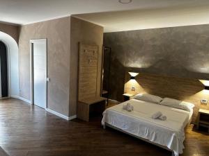 蒙特-坡佐-卡多Casa Catone (affitta camere)的一间卧室设有一张床和一个大墙