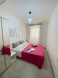 锡拉库扎Casa 68 Ortigia的一间卧室配有一张带粉色毯子的大床
