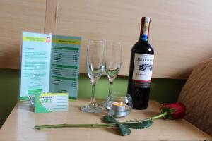 基多Hostal Terra 2 - EL CONDADO的桌子上放有一瓶葡萄酒和两杯酒