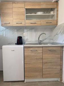 克里斯阿穆迪亚STUDIOS TASOS BI的厨房配有水槽和白色冰箱