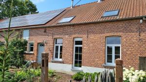 赫罗本东克Boshovense Velden的屋顶上设有太阳能电池板的红砖房子