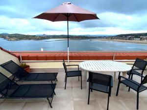 苏安塞斯Playa de los Locos con Garaje的庭院配有桌椅和遮阳伞。