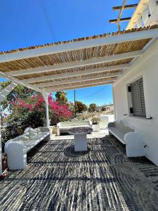 弗通Santorini Style Rooms的天井配有沙发、桌子和凉亭。