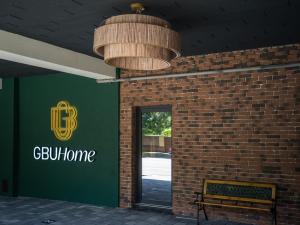 蒂米什瓦拉GBU Home Timisoara的绿色标志和长凳的建筑