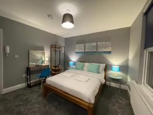 伦敦Small Double Studio close to King's Cross & Camden的一间卧室配有一张床和一张带两盏灯的书桌。