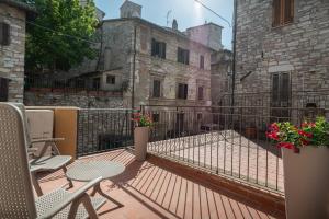阿西西Xenios Assisi的一个带桌椅的阳台和一座建筑
