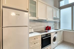 雅典Athenian Vintage Apartments的厨房配有白色橱柜和冰箱。