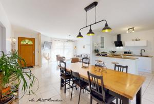勒比格Au petit bonheur的厨房以及带木桌和椅子的用餐室。