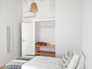 圣罗克Terreiro Ocean House - Sea View的卧室拥有白色的墙壁,配有带枕头的床铺。
