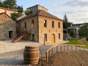 贝尔切托Agriturismo Il Mulino della Rocca的一座古老的石头建筑,前面有桶