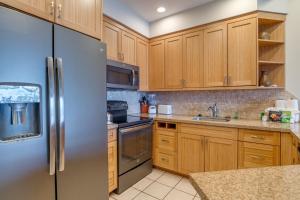 卡哈纳哈勒马西纳B403号公寓的厨房配有木制橱柜和不锈钢冰箱。