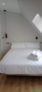 维戈Príncipe Boutique apartments的一张白色的床,上面有两张折叠毛巾