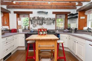 阿维莫尔The Polchar - Aviemore的厨房配有白色橱柜和木制台面