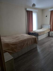 巴库里阿尼Дом гарах的一间卧室设有两张床、一个窗户和木地板。