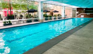 墨西哥城Casa Vive Grand by Kukun的大楼里的一个大型蓝色游泳池