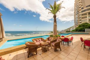 维纳德马Oceana Suites Eurovista的一个带游泳池、椅子和棕榈树的庭院