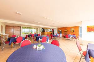维纳德马Oceana Suites Eurovista的用餐室配有蓝色的桌子和红色的椅子